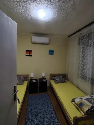 a room with two beds in a room with a ceiling at STD Havela in Kovačica