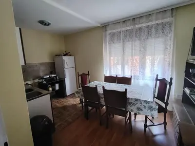 a dining room with a table and chairs and a kitchen at STD Havela in Kovačica