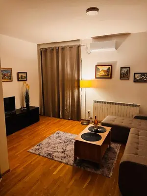 a living room with a couch and a table at Apartman 69 in Krnjača