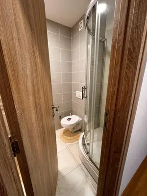a bathroom with a toilet and a glass shower at Apartman 69 in Krnjača