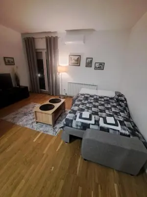 a bedroom with a bed and a coffee table at Apartman 69 in Krnjača
