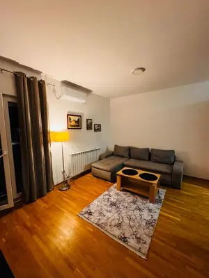 a living room with a couch and a table at Apartman 69 in Krnjača