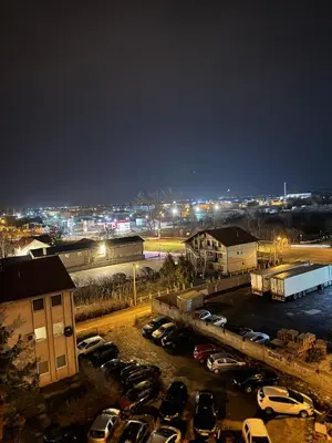 a parking lot with a bunch of parked cars at night at Apartman 69 in Krnjača