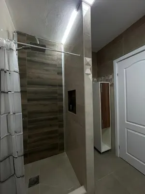 a shower with a glass door in a bathroom at Apartman Dora in Ruma