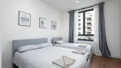 two beds in a white room with a window at Belgrade Waterfront Quartet 1 in Belgrade
