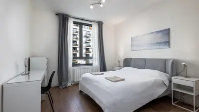 a white bedroom with a bed and a window at Belgrade Waterfront Quartet 1 in Belgrade