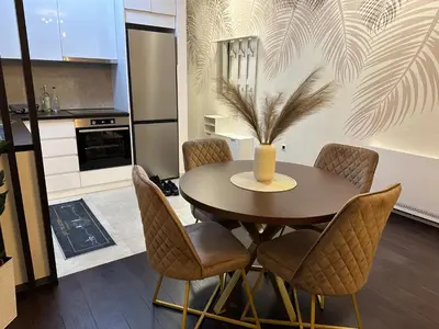 a dining room table with chairs and a vase on it at Suzi in Belgrade