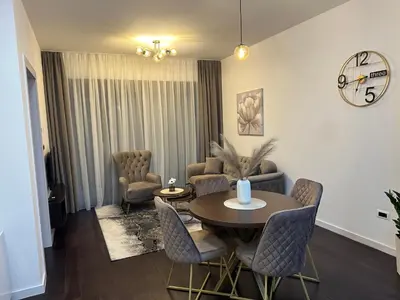 a living room with a table and chairs and a clock at Suzi in Belgrade