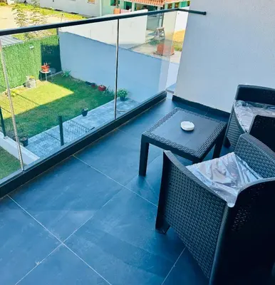 a balcony with a table and chairs and a view of a yard at Suzi in Belgrade