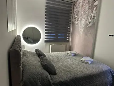 a bedroom with a bed with pillows and a mirror at Suzi in Belgrade