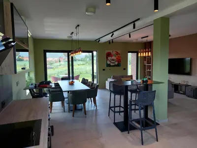a kitchen and dining room with a table and chairs at Kosmaj IKIGAI in Nemenikuće
