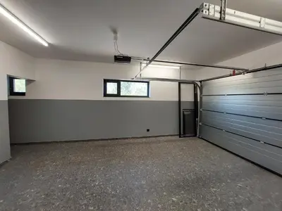 an empty garage with two garage doors and a window at Kosmaj IKIGAI in Nemenikuće