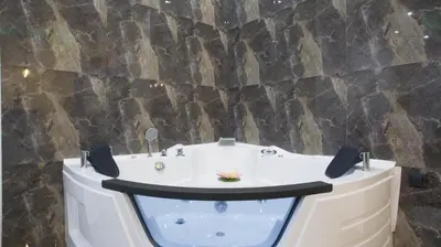 a bath tub in front of a stone wall at New Moment Lux in Žarkovo