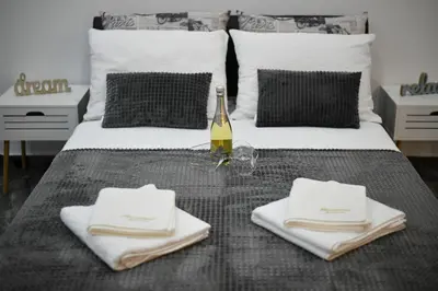 a bed with a table with towels and a bottle of wine at New Moment Lux in Žarkovo