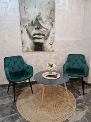 two green chairs and a table in a room at New Moment Lux in Žarkovo