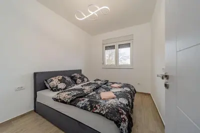 a bedroom with a bed in a white room at Hemingway Belgrade Apartment in Zemun