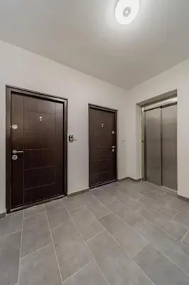 a empty room with three doors and a tile floor at Hemingway Belgrade Apartment in Zemun