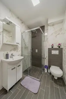 a bathroom with a shower and a toilet and a sink at Hemingway Belgrade Apartment in Zemun
