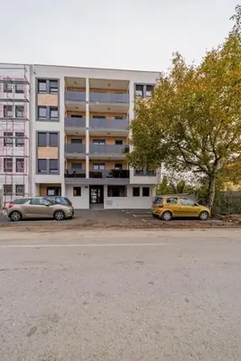 two cars parked in a parking lot in front of a building at Hemingway Belgrade Apartment in Zemun