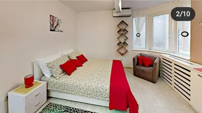 a bedroom with a bed with red pillows and a chair at Terazije 3 in Belgrade