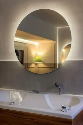 a bathroom with a sink and a round mirror at Kovac Spa Belgrade Apartment in Belgrade