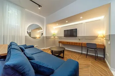 a living room with a blue couch and a table at Kovac Spa Belgrade Apartment in Belgrade