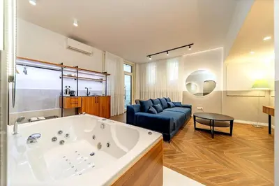 a large bathroom with a large tub and a couch at Kovac Spa Belgrade Apartment in Belgrade