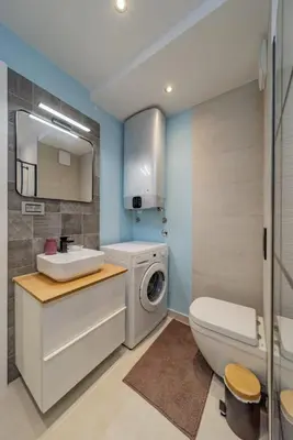 a bathroom with a sink and a washing machine at Ritual Belgrade Apartment in Belgrade