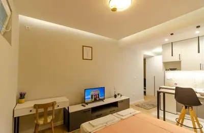 a room with a desk with a computer and a kitchen at Aleksa&Una in Ledine