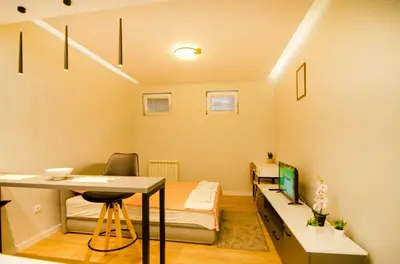 a small room with a bed and a desk and a table at Aleksa&Una in Ledine