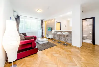a living room with a red couch and a table at Apartments King Milan, City Center in Belgrade
