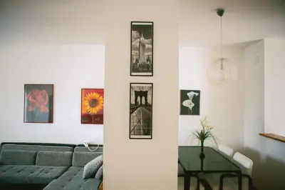 a living room with a couch and pictures on the wall at Viktorija Apartment in Belgrade