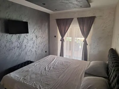 a bedroom with a bed and a tv on the wall at Apartmani Lux Filipovic in Smederevo