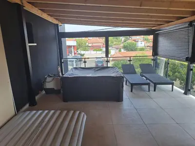 a room with a bed and benches on a balcony at Apartmani Lux Filipovic in Smederevo