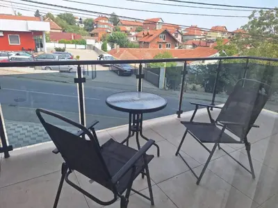 a patio with two chairs and a table on a balcony at Apartmani Lux Filipovic in Smederevo