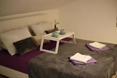 a bed with a small table on top of it at New Moment Lux 2 in Žarkovo