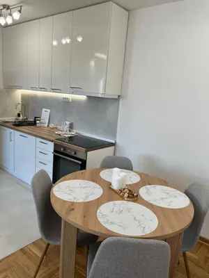 a kitchen with a wooden table and chairs at Apartment Ninana in Belgrade