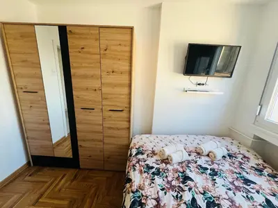 a bedroom with a bed and a closet and a television at Apartment Ninana in Belgrade