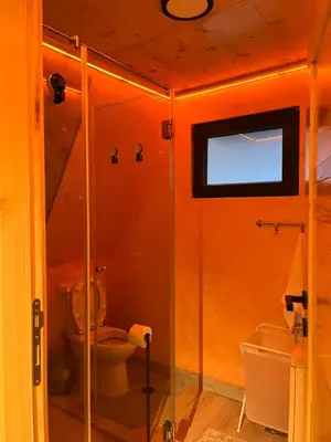 a bathroom with a toilet and a glass shower at Apartman Durtanoski 1 in Mali Mokri Lug