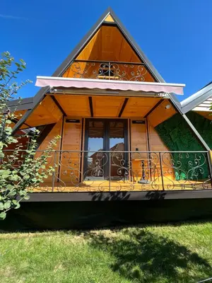 a house with a balcony in the grass at Apartman Durtanoski 1 in Mali Mokri Lug