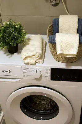 a washing machine with towels on top of it at Aura Apartment - Lovely Apartment with Garage Parking in Belgrade