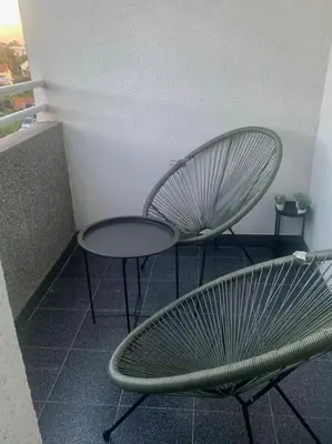 two metal chairs and a table on a balcony at Aura Apartment - Lovely Apartment with Garage Parking in Belgrade
