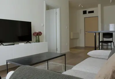 a living room with a tv and a table at Aura Apartment - Lovely Apartment with Garage Parking in Belgrade