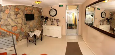 a hallway with a table and a stone wall at Bed & Breakfast Garden40 in Belgrade