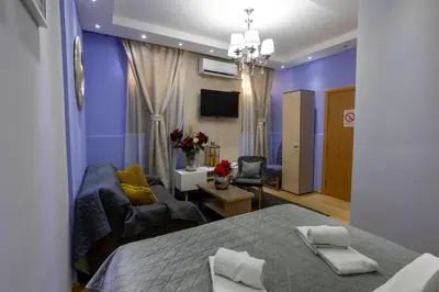 a bedroom with a bed and a living room with a couch at Bed & Breakfast Garden40 in Belgrade