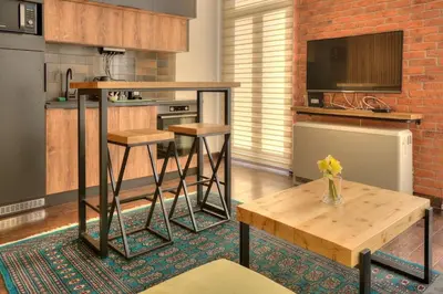 a kitchen with a counter and a table with stools at Knez Central Apartment in Belgrade