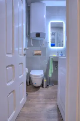 a bathroom with a white toilet and a sink at Knez Central Apartment in Belgrade