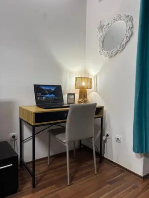 a desk with a laptop and a chair in a room at Mina 1 in Belgrade