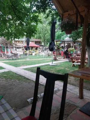 a park with a bench and a table with umbrellas at Etno selo Dukat in Belo Polje