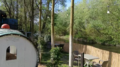 a table and chairs next to a river at Etno selo Dukat in Belo Polje